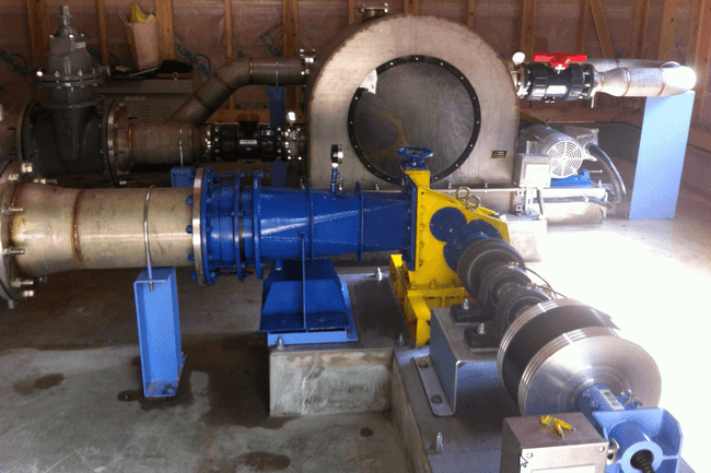 Low-head gravitational water vortex turbine on a river channel